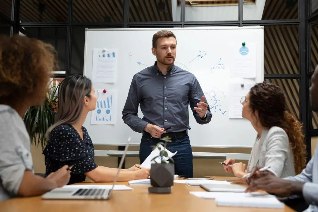 Confident businessman executive talk to employees during corporate briefing